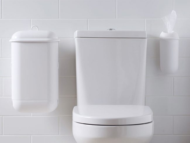 A washroom image with white Pod Petite Manual unit and white Wet Wipe dispenser installed beside toilet