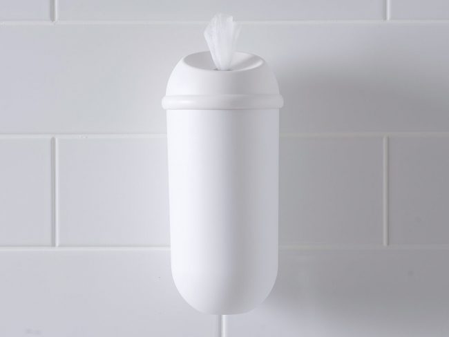 The white Wet Wipe dispenser on a white tiled wall