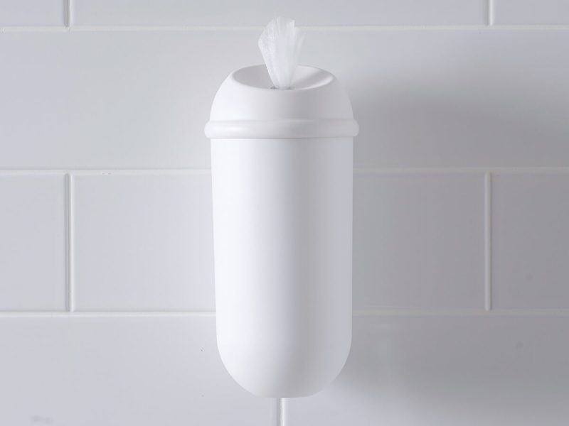 The white Wet Wipe dispenser on a white tiled wall
