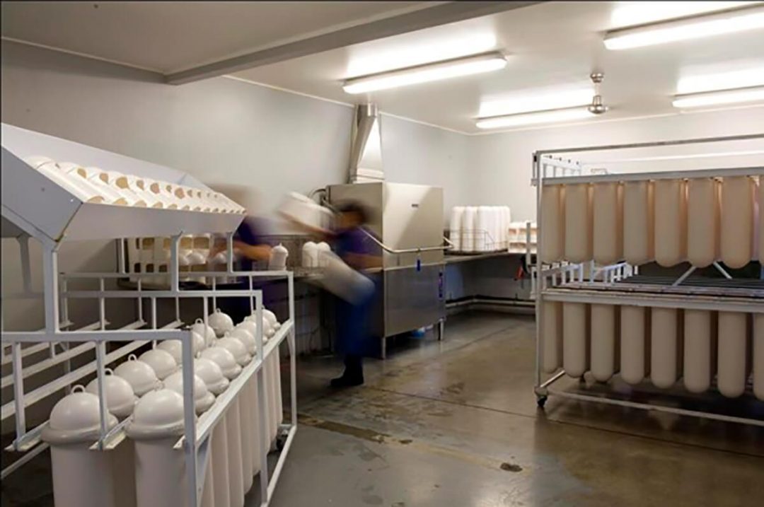 A hygiene service company washing racks of SaniPods in a warehouse