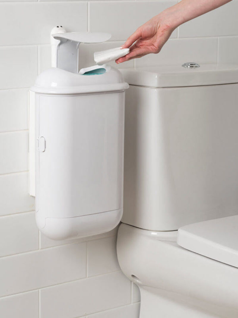 A person using a SaniPod Pod Petite white automatic unit