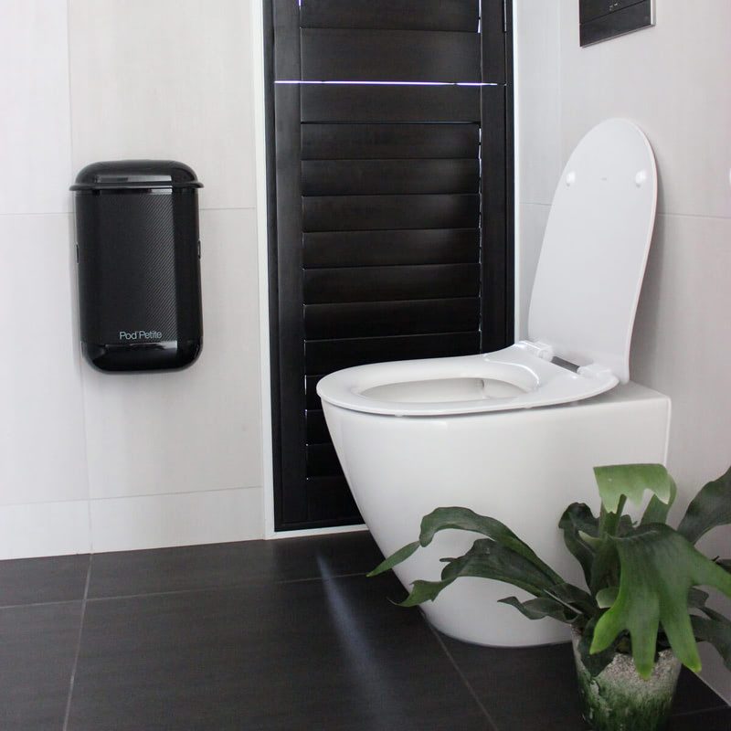 A black Pod Petite sanitary disposal unit with a Pod Wrap Carbon Fibre decal.