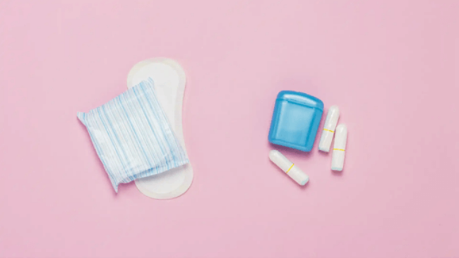 Feminine Hygiene Tips – pads and tampons on a pink background