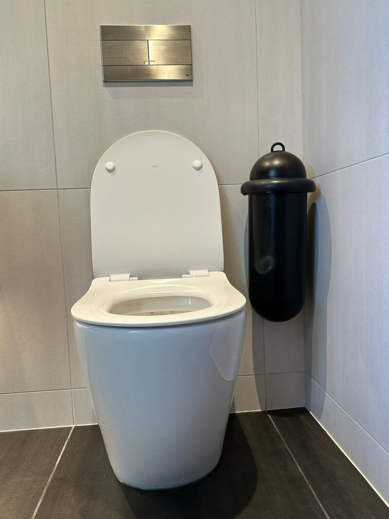 Pod Classic Mini Manual Black sanitary unit in washroom cubicle