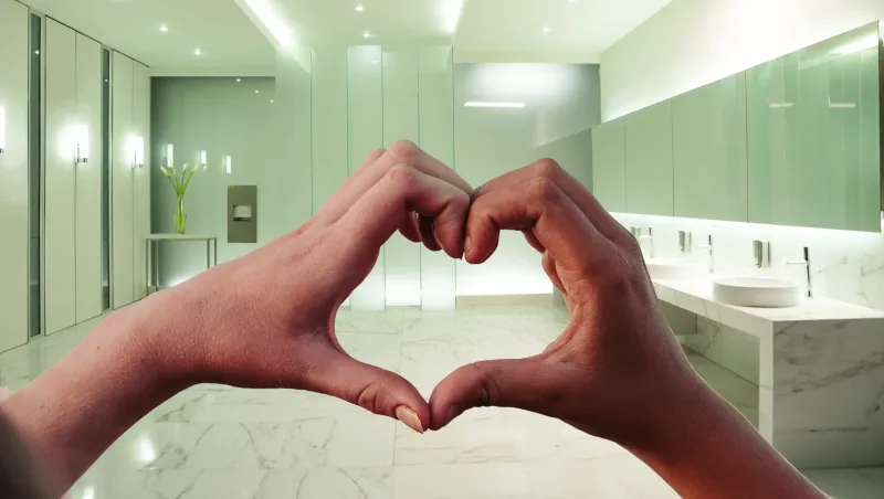 Washroom image with heart hand signalling corporate and sustainable responsibility