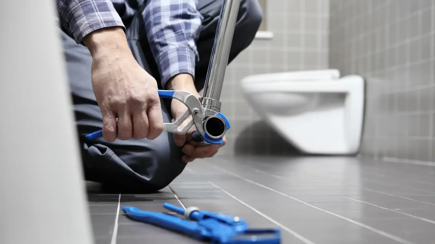 Plumbing costs – plumber working on bathroom