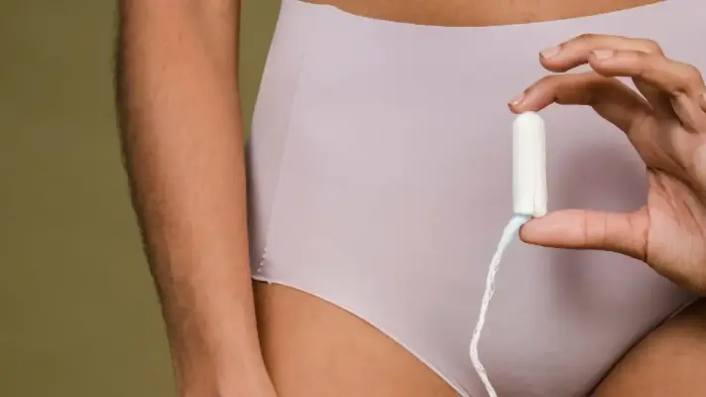 how to dispose of tampons - Close-up of a woman in underwear holding a tampon