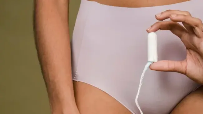 how to dispose of tampons - Close-up of a woman in underwear holding a tampon